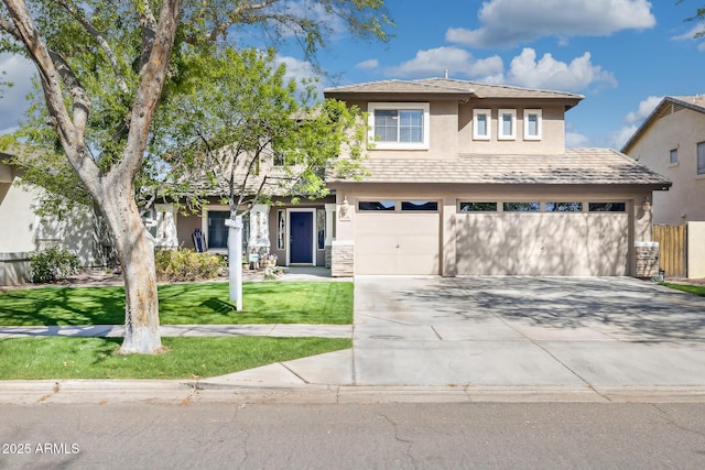 view of front of property featuring a front yard, a garage, driveway, and stucco siding