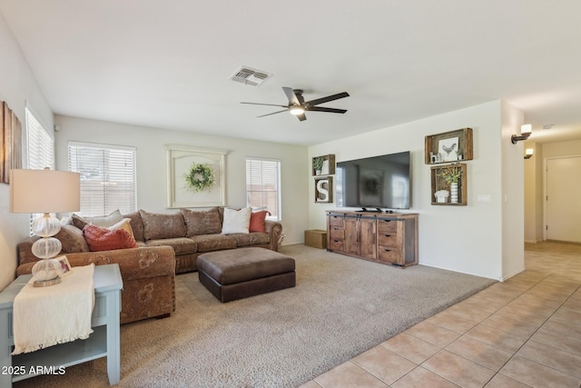 living area with light tile patterned floors, visible vents, plenty of natural light, and light colored carpet