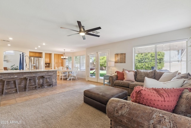 living area featuring a wealth of natural light, light tile patterned floors, recessed lighting, and ceiling fan with notable chandelier