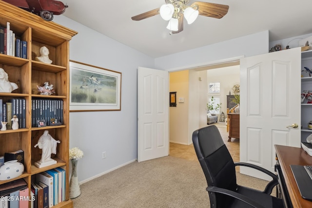 office space with ceiling fan, baseboards, and light carpet