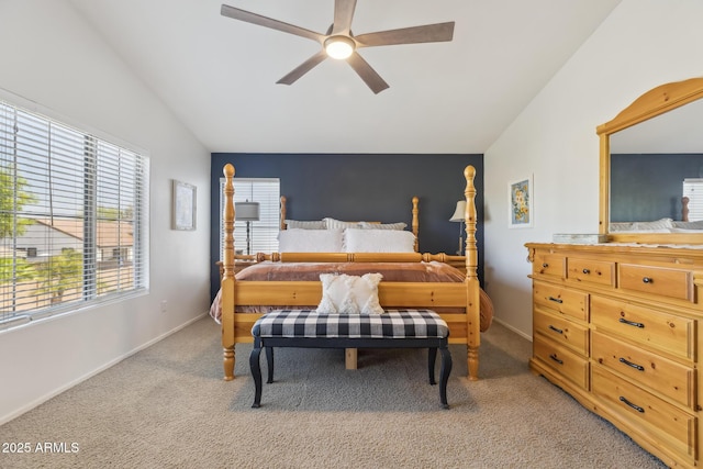 bedroom featuring light carpet, ceiling fan, baseboards, and vaulted ceiling