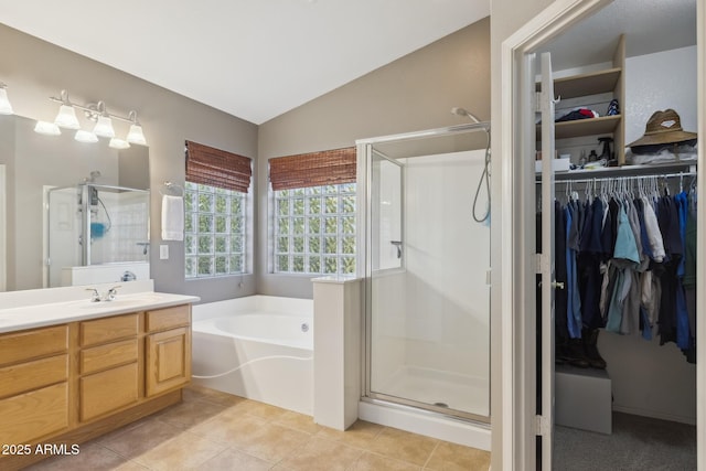 bathroom featuring tile patterned floors, a stall shower, vanity, and vaulted ceiling