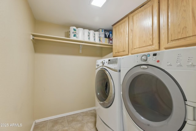 laundry area featuring cabinet space, light tile patterned floors, separate washer and dryer, and baseboards