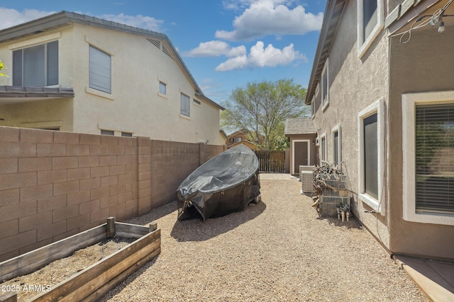 exterior space with central air condition unit, a vegetable garden, and a fenced backyard