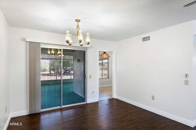 unfurnished room with dark hardwood / wood-style flooring, plenty of natural light, and a notable chandelier