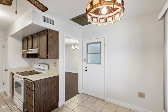 kitchen with ceiling fan with notable chandelier, white range with electric stovetop, and light tile patterned floors