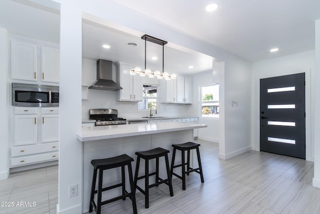 1011 W Weldon Ave, Phoenix, AZ 85013 - kitchen with wall chimney range hood, appliances with stainless steel finishes, a sink, baseboards, and white cabinetry