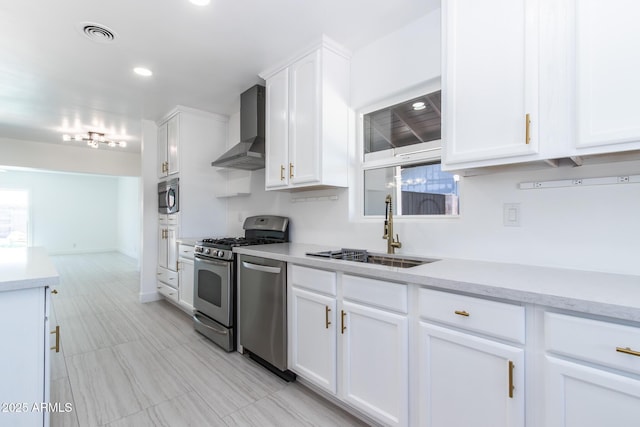 1011 W Weldon Ave, Phoenix, AZ 85013 - kitchen featuring wall chimney range hood, stainless steel appliances, a sink, white cabinets, and healthy amount of natural light