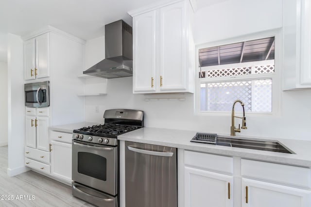 1011 W Weldon Ave, Phoenix, AZ 85013 - kitchen featuring appliances with stainless steel finishes, wall chimney range hood, a sink, and white cabinetry