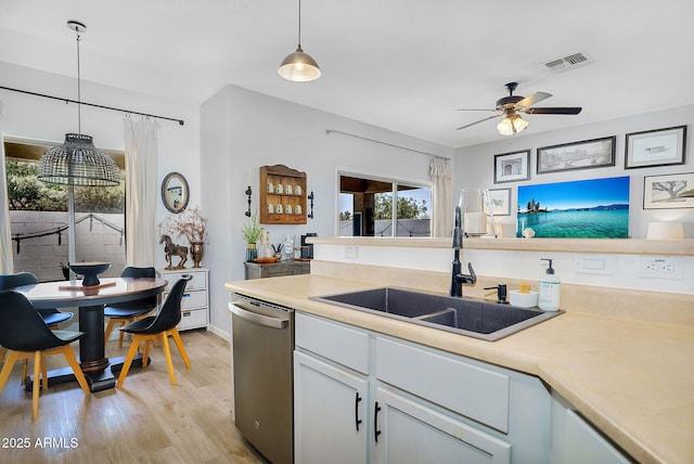 948 E Savannah Dr, Chandler, AZ 85225 - kitchen featuring stainless steel dishwasher, a sink, a ceiling fan, light wood-type flooring, and light countertops