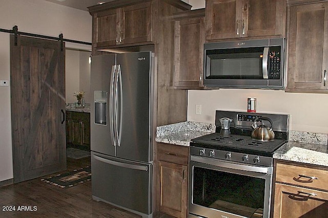 860 W Snow Creek Trl, Show Low, AZ 85901 - kitchen with appliances with stainless steel finishes, dark wood-style flooring, a barn door, and dark brown cabinets
