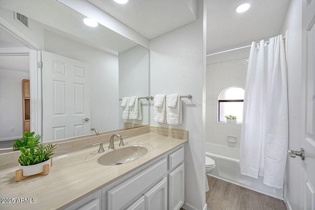 full bathroom featuring shower / bath combo, hardwood / wood-style floors, vanity, and toilet