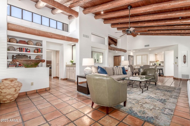 tiled living room with wood ceiling, built in features, ceiling fan, a high ceiling, and beamed ceiling