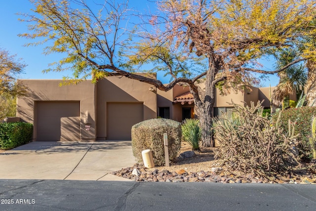 pueblo revival-style home featuring a garage