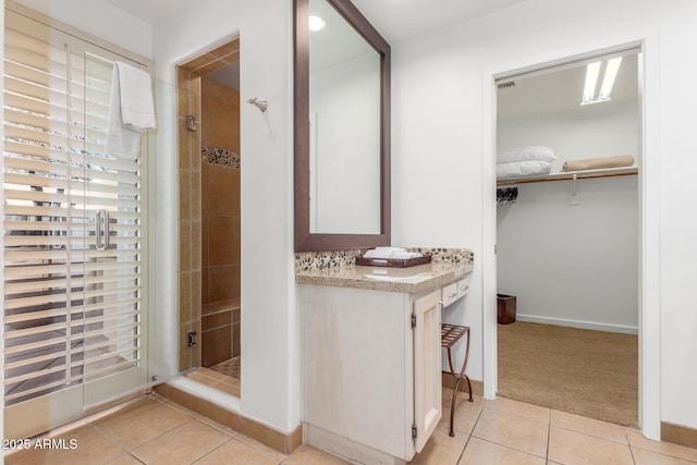 bathroom with tile patterned flooring, vanity, and an enclosed shower