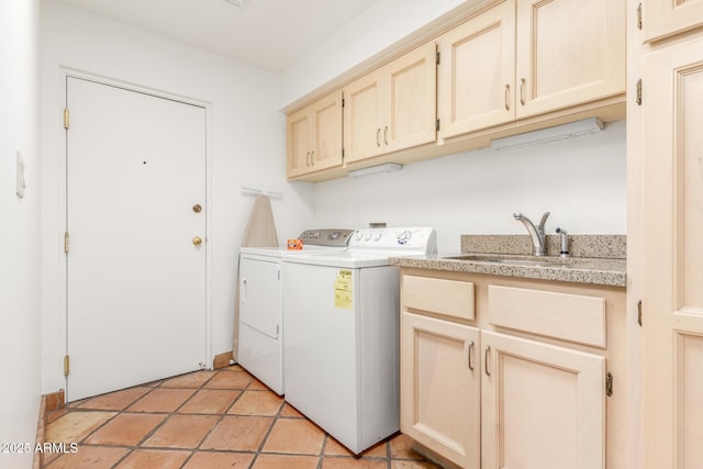 washroom with sink, cabinets, washer and dryer, and light tile patterned flooring