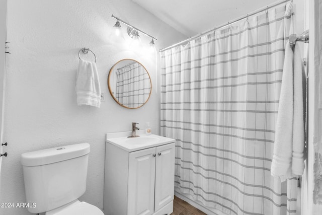 bathroom with hardwood / wood-style flooring, vanity, curtained shower, and toilet