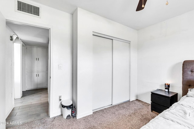 carpeted bedroom featuring a closet and ceiling fan