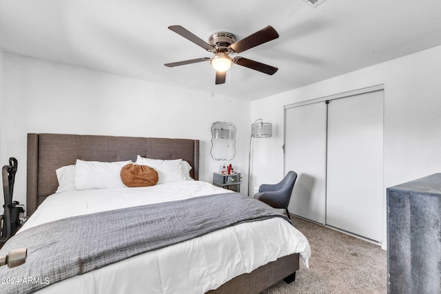 bedroom featuring light colored carpet, ceiling fan, and a closet