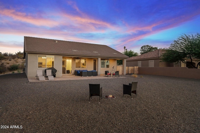 back house at dusk featuring a patio and outdoor lounge area