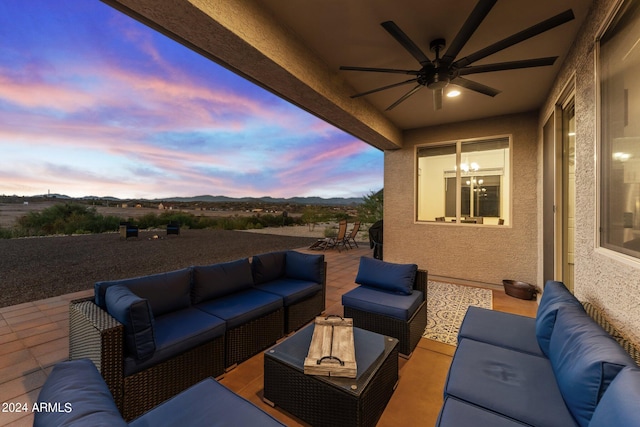 patio terrace at dusk with an outdoor living space and ceiling fan