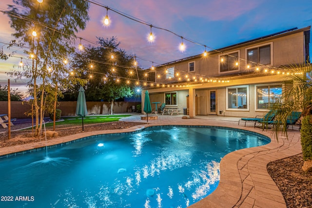 pool at dusk with a patio