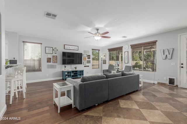 living room featuring dark wood-type flooring and ceiling fan