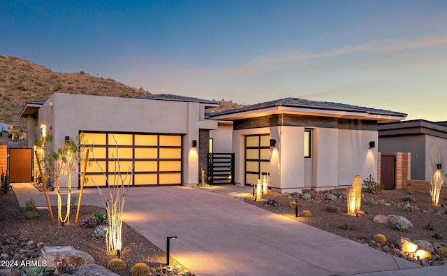 view of front of home with an attached garage, driveway, and stucco siding