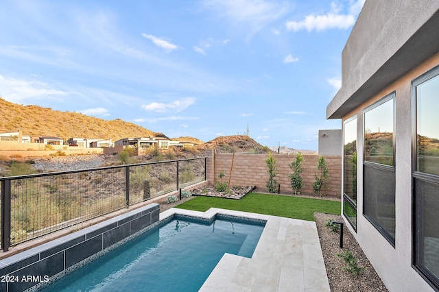 view of pool with a fenced backyard and a lawn