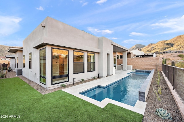 back of property with a fenced in pool, a patio, a lawn, a fenced backyard, and stucco siding