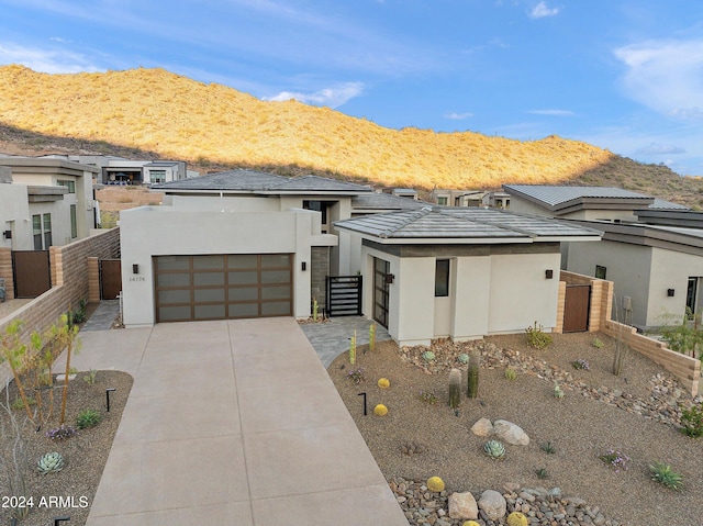 view of front of home featuring an attached garage, fence, concrete driveway, and stucco siding