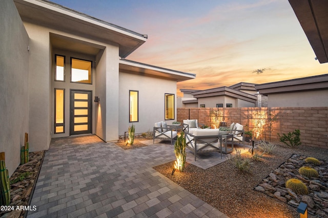 patio terrace at dusk featuring an outdoor living space