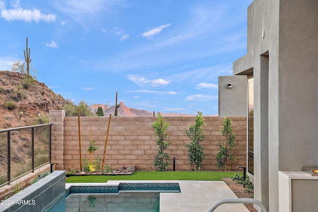 view of pool featuring a patio area, a fenced backyard, a mountain view, and a fenced in pool