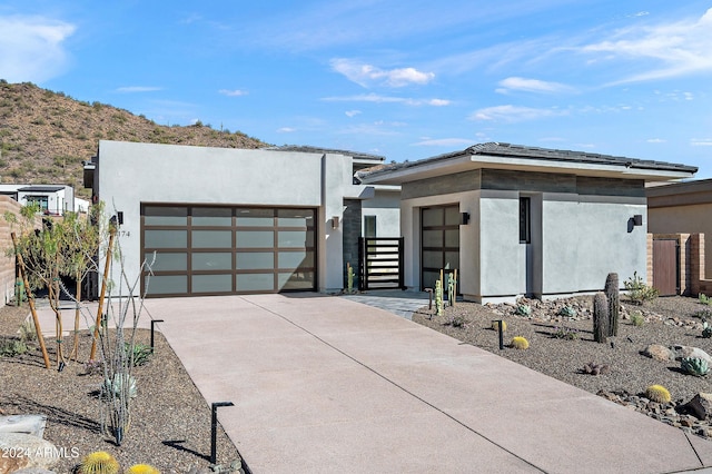 view of front of home with an attached garage, concrete driveway, and stucco siding