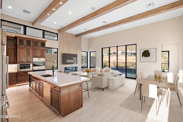 kitchen featuring visible vents, open floor plan, a sink, and oven