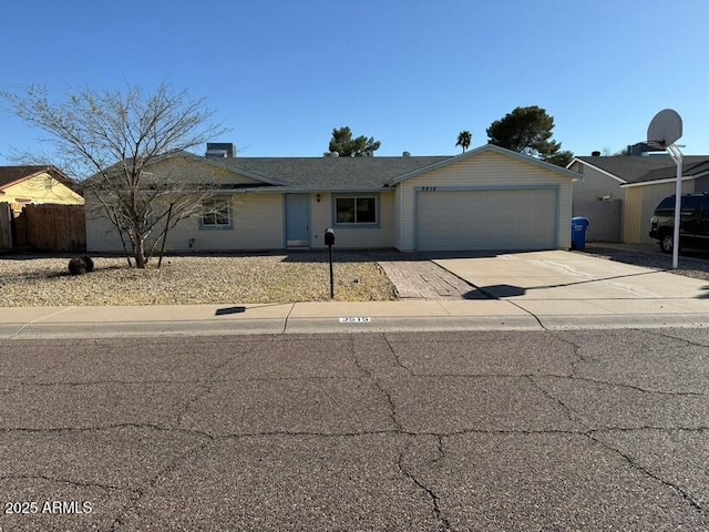 ranch-style house with concrete driveway, a garage, and fence