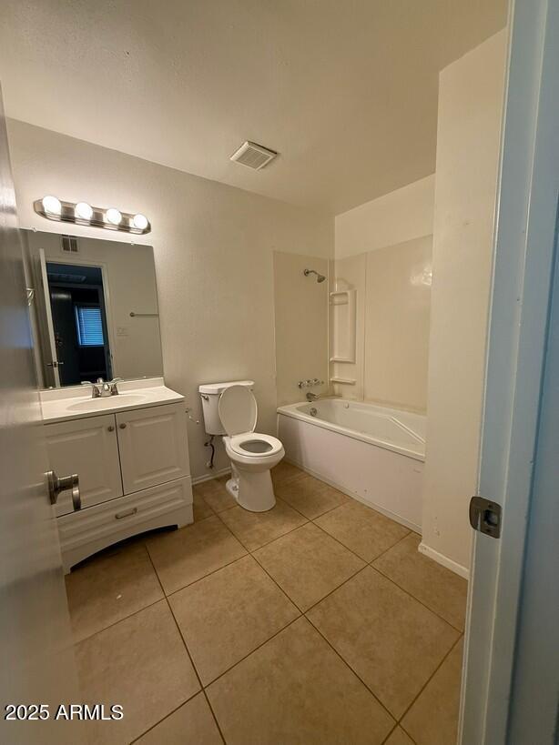 full bath featuring vanity, visible vents, bathtub / shower combination, tile patterned floors, and toilet