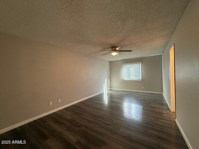 spare room with dark wood finished floors, a textured ceiling, baseboards, and a ceiling fan