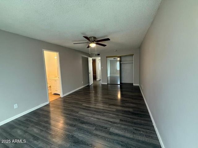 unfurnished room featuring baseboards, a textured ceiling, ceiling fan, and dark wood-style flooring