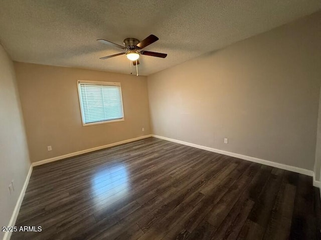 spare room with baseboards, dark wood-type flooring, ceiling fan, and a textured ceiling