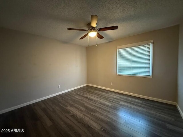 spare room featuring a ceiling fan, dark wood-style floors, baseboards, and a textured ceiling