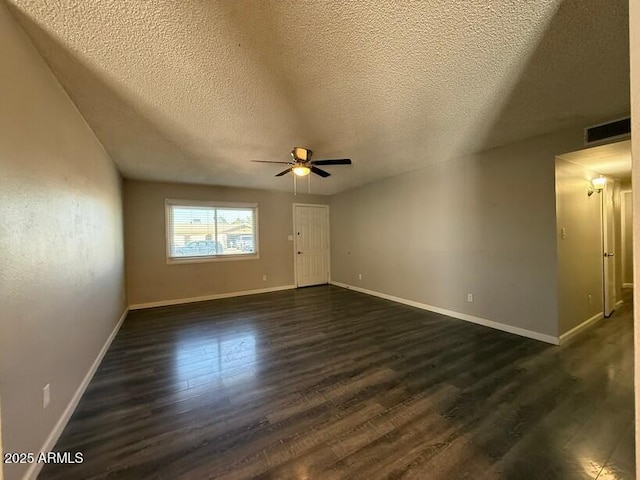 unfurnished room with visible vents, baseboards, a ceiling fan, and dark wood-style flooring