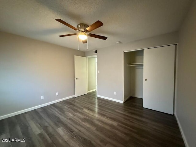 unfurnished bedroom featuring visible vents, baseboards, dark wood finished floors, a closet, and a textured ceiling