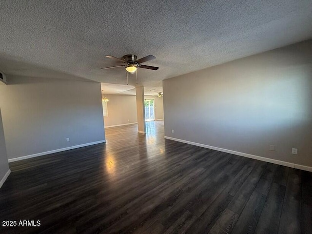 spare room featuring a textured ceiling, baseboards, dark wood-type flooring, and ceiling fan with notable chandelier