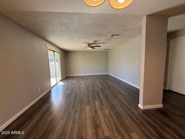 spare room with visible vents, a ceiling fan, a textured ceiling, dark wood-style floors, and baseboards