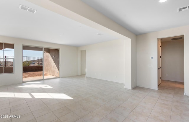 spare room featuring visible vents, baseboards, and light tile patterned floors