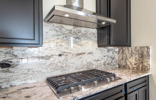 kitchen with tasteful backsplash, stainless steel gas stovetop, and wall chimney range hood