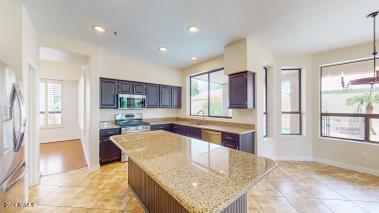 kitchen featuring a center island, a wealth of natural light, stainless steel appliances, and light stone countertops