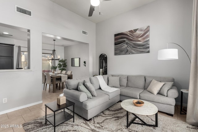 living room featuring ceiling fan with notable chandelier and light tile patterned floors