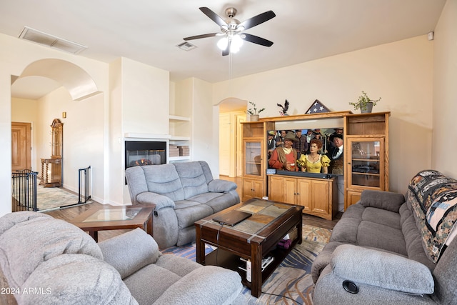 living room featuring hardwood / wood-style floors, ceiling fan, and built in features